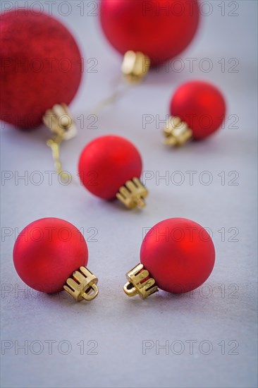 Composition of small and big red christmas balls on grey background