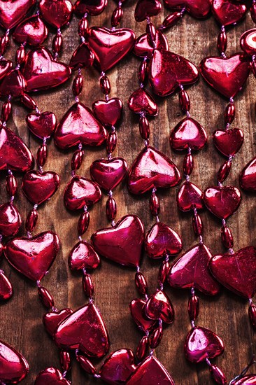 Background red valentines beads garland on old wooden board