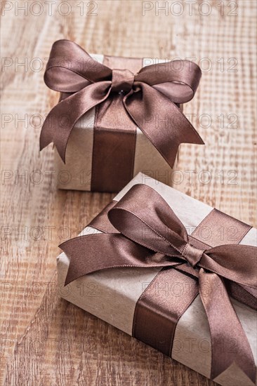 Pintage brown paper gift boxes with ribbon on wooden board concept