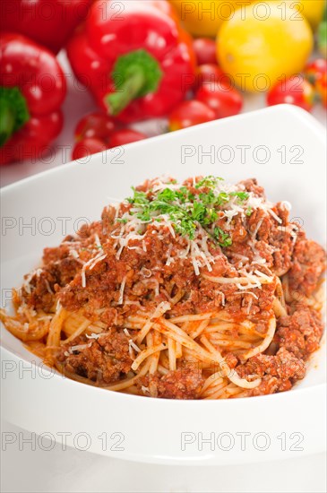 Italian classic spaghetti with bolognese sauce and fresh vegetables on background