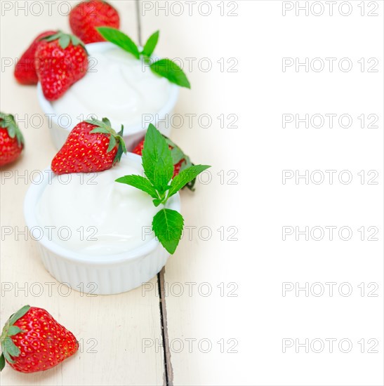 Organic Greek yogurt and strawberry over white rustic wood table