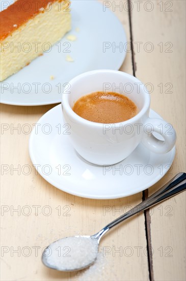 Italian espresso coffee and cheese cake over white wood table