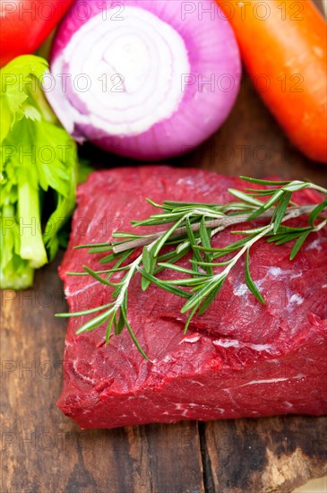 Fresh raw beef cut ready to cook with vegetables and herbs