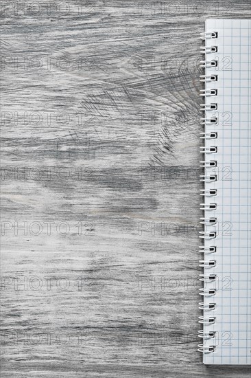 Checked note-book on wooden board copy space office concept