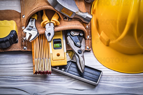 Safety building helmet toolbelt on wooden board construction concept