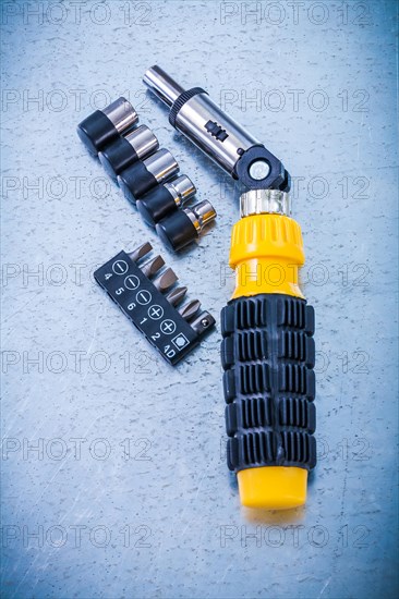 Vertical view of reversible screwdrivers and Torxes on a metallic background Design concept