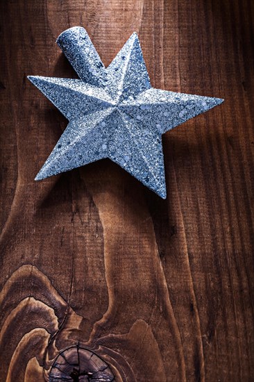 Christmas toy star for Christmas tree on old wooden background