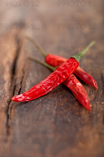 Dry red chili peppers over old wood table