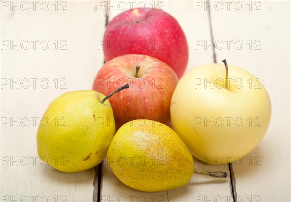 Fresh fruits apples and pears on a white wood table