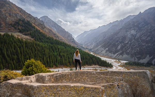 Hiker enjoying the view of the Ala Archa valley from the viewpoint at broken heart rock