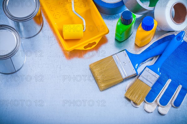 Household tapes protective gloves and paint tools on metallic background construction concept