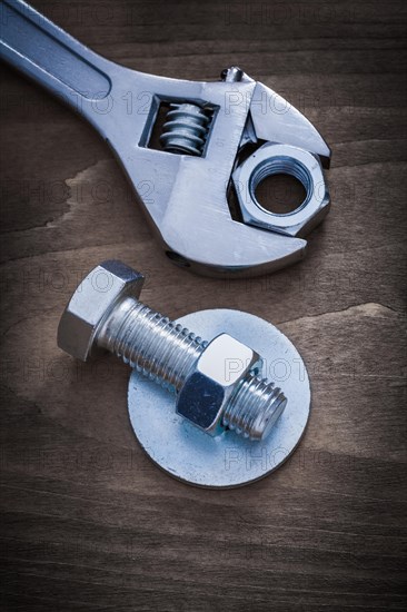 Adjustable key bolt washer screw-nut and bolt on wooden background