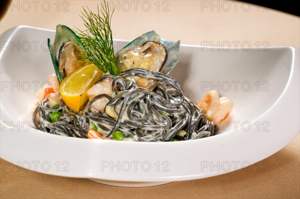 Fresh seafood black squid ink coulored spaghetti pasta tipycal italian food