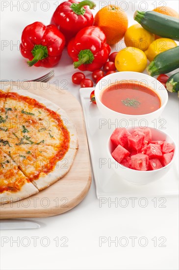 Italian original thin crust pizza Margherita with gazpacho soup and watermelon on side