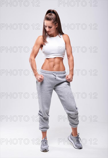 Young white fitness woman wearing sportswear standing over white wall background. Fitness concept. Mixed media