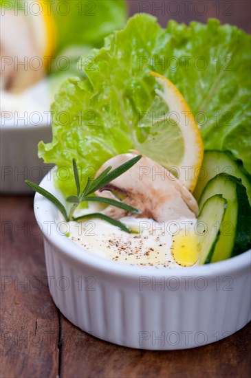 Fresh organic garlic cheese dip salad on a rustic table