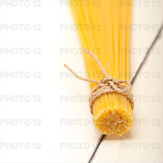 Italian pasta spaghetti tied with a rope on a rustic table