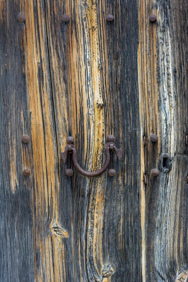 Old wooden door with aged metal door handle. Architectural textured background