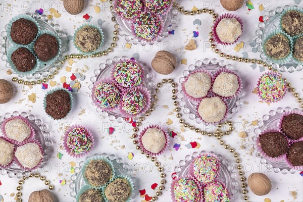 Light and dark rum balls on and next to glass plates