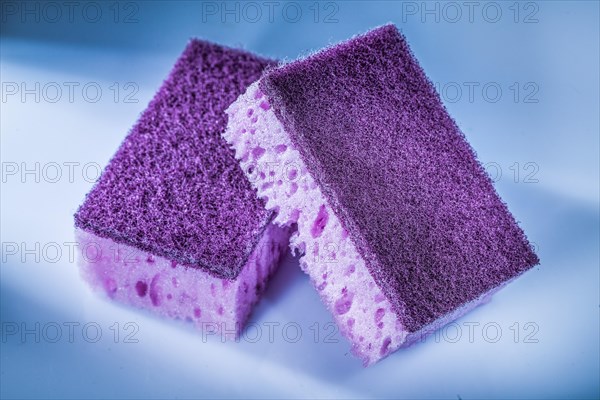 New violet kitchen sponges on white surface