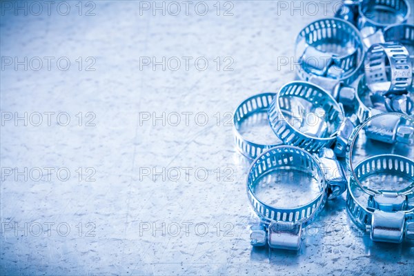 Copy space image of stainless steel hollowed hose clamps on metallic background construction concept