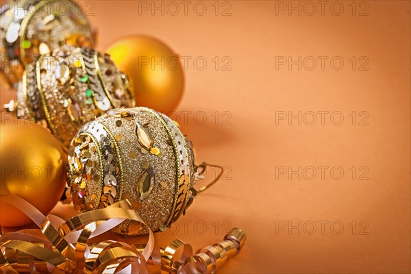 Composition of golden Christmas baubles on a light brown background