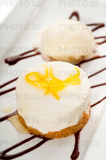 Very elegant lemon mousse dessert served whith lemon peel on top and vanilla ice cream on side