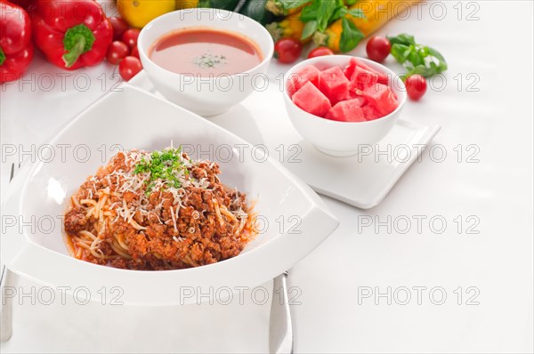 Italian classic spaghetti with bolognese sauce and fresh vegetables on background