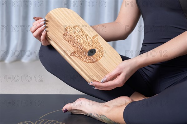 Image of a Sadhu board in female hands. Yoga concept. Spiritual practices. Mixed media