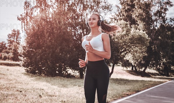 Sports girl jogging in the park. The concept of a healthy lifestyle. Sports Equipment. Fitness style advertisement. Mixed media