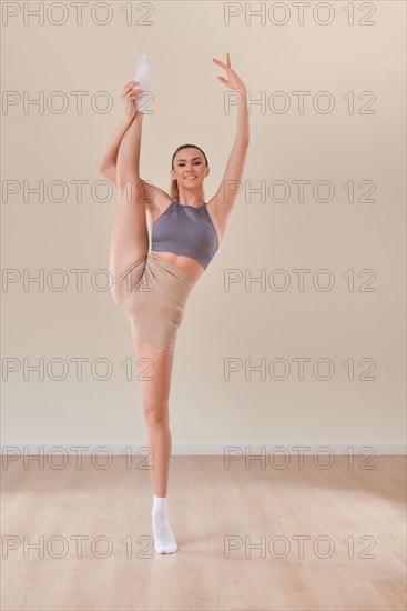 Image of a beautiful woman posing in a bright studio near the hammocks. The concept of airstretching. Fitness and sports