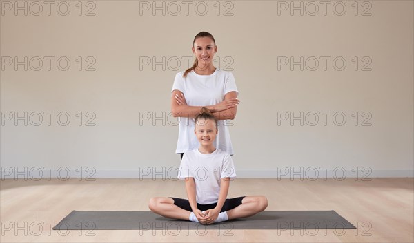 Beautiful female teacher poses with a little girl in a gymnastics class. The concept of education