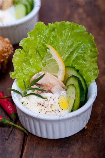 Fresh organic garlic cheese dip salad on a rustic table