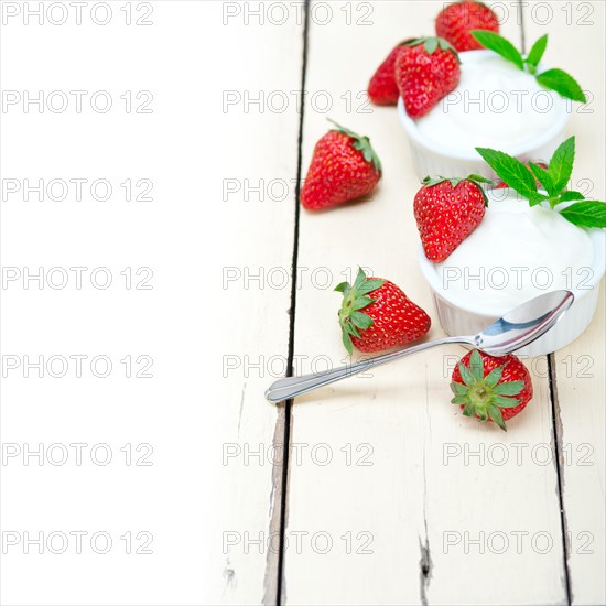 Organic Greek yogurt and strawberry over white rustic wood table