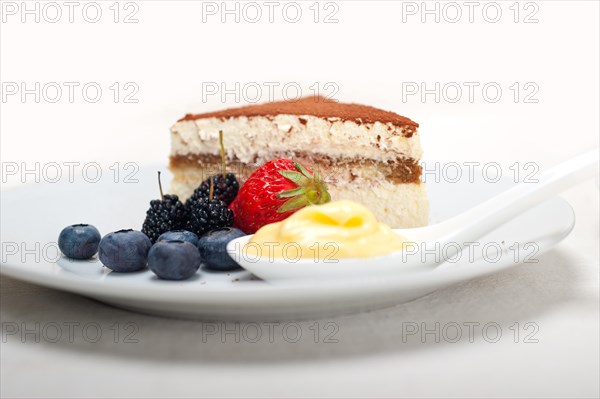 Classic Italian tiramisu dessert with berries and custartd pastry cream on side