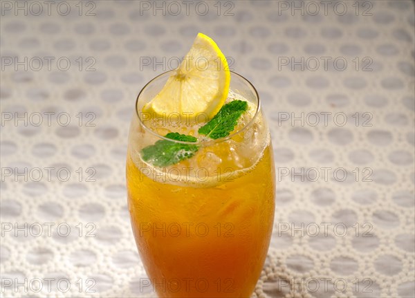 Refreshing Ice tea closeup macro with lemon and mint leaves