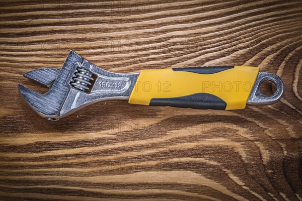 Adjustable spanner on vintage wooden board construction concept