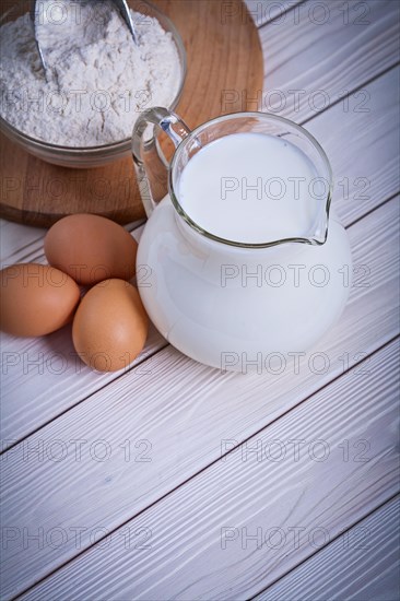 Aerial view Egg Milk jug Flour Bowl on white painted wooden board Food and drink Still life