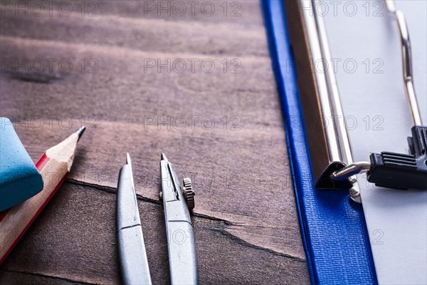 Eraser pencil compass clipboard very close to vintage wooden board learning concept v