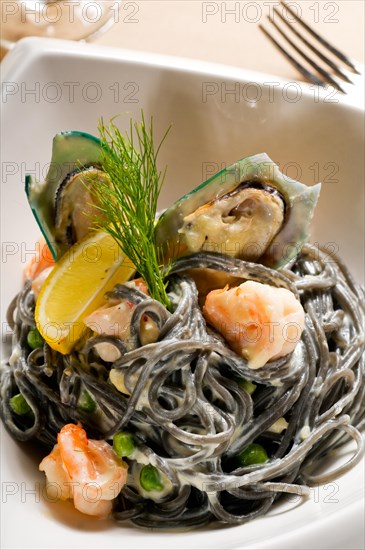 Fresh seafood black squid ink coulored spaghetti pasta tipycal italian food