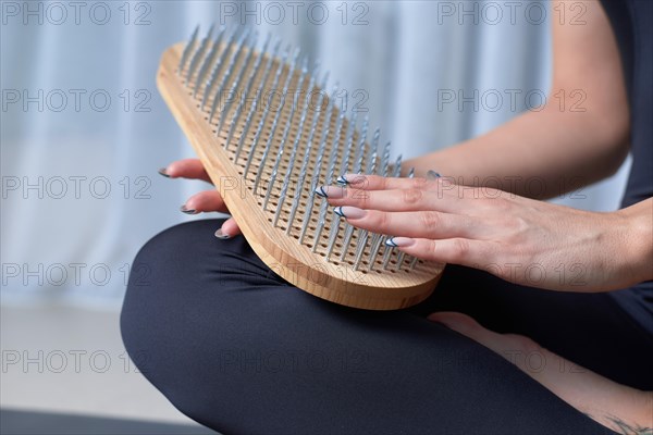 Image of a Sadhu board in female hands. Yoga concept. Spiritual practices. Mixed media