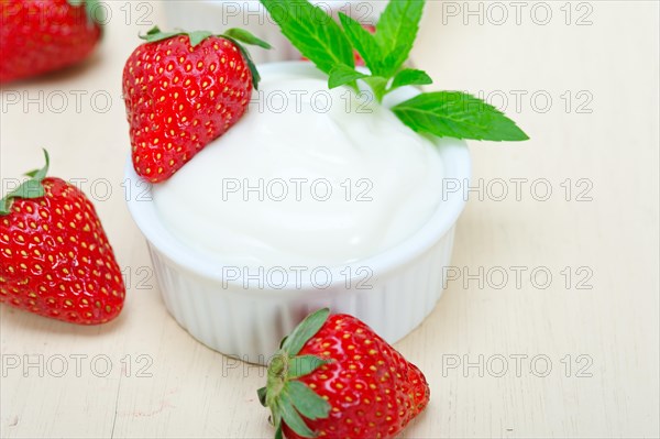 Organic Greek yogurt and strawberry over white rustic wood table