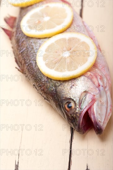 Fresh whole raw fish on a wooden table ready to cook