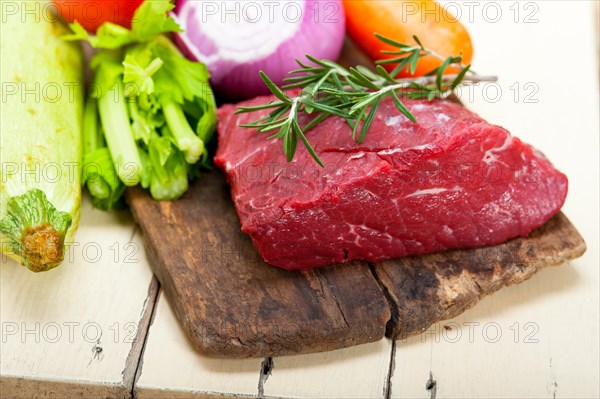 Fresh raw beef cut ready to cook with vegetables and herbs