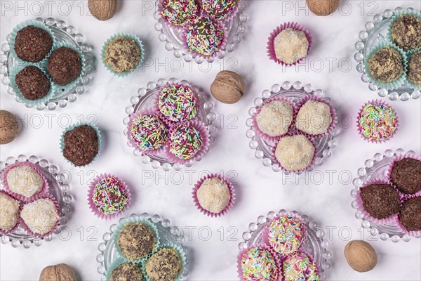 Light and dark rum balls on and next to glass plates