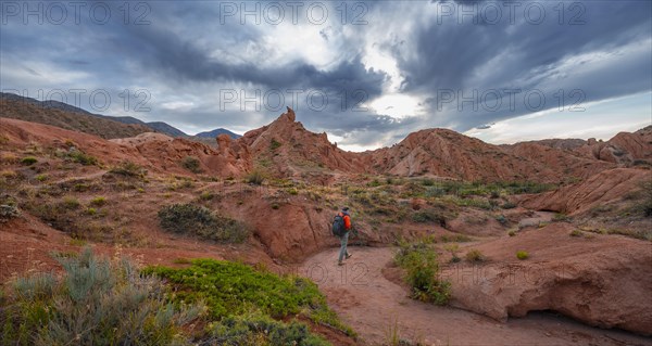 Tourist hikes through canyon of eroded sandstone formations