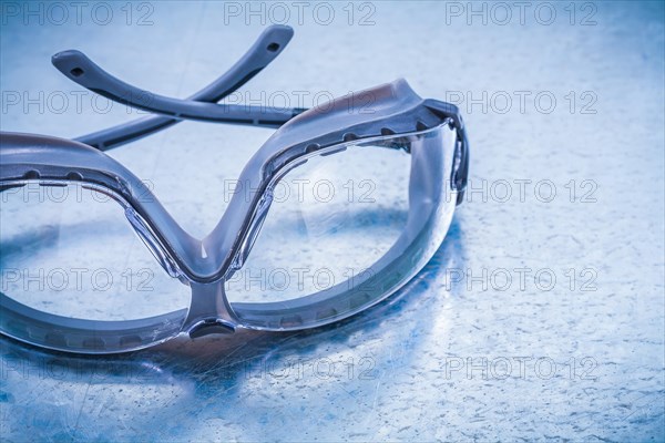 Plastic safety spectacles on a metallic background Design concept