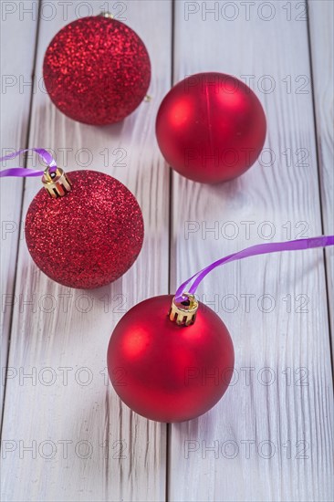 Composition of red Christmas baubles on white lacquered plates