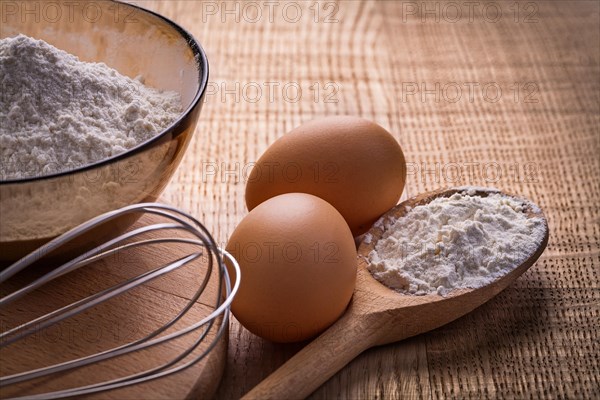 Corolla eggs flour in spoon and bowl on wooden board food and drink still life