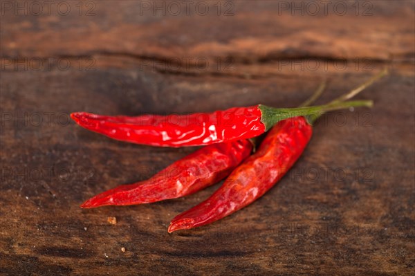 Dry red chili peppers over old wood table